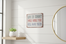 Load image into Gallery viewer, Life Is Too Short Smile metal wall sign in bright cheerful room